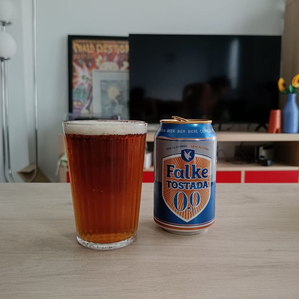 Lata de cerveza falke 00 tostada de Mercadona vertida sobre un vaso